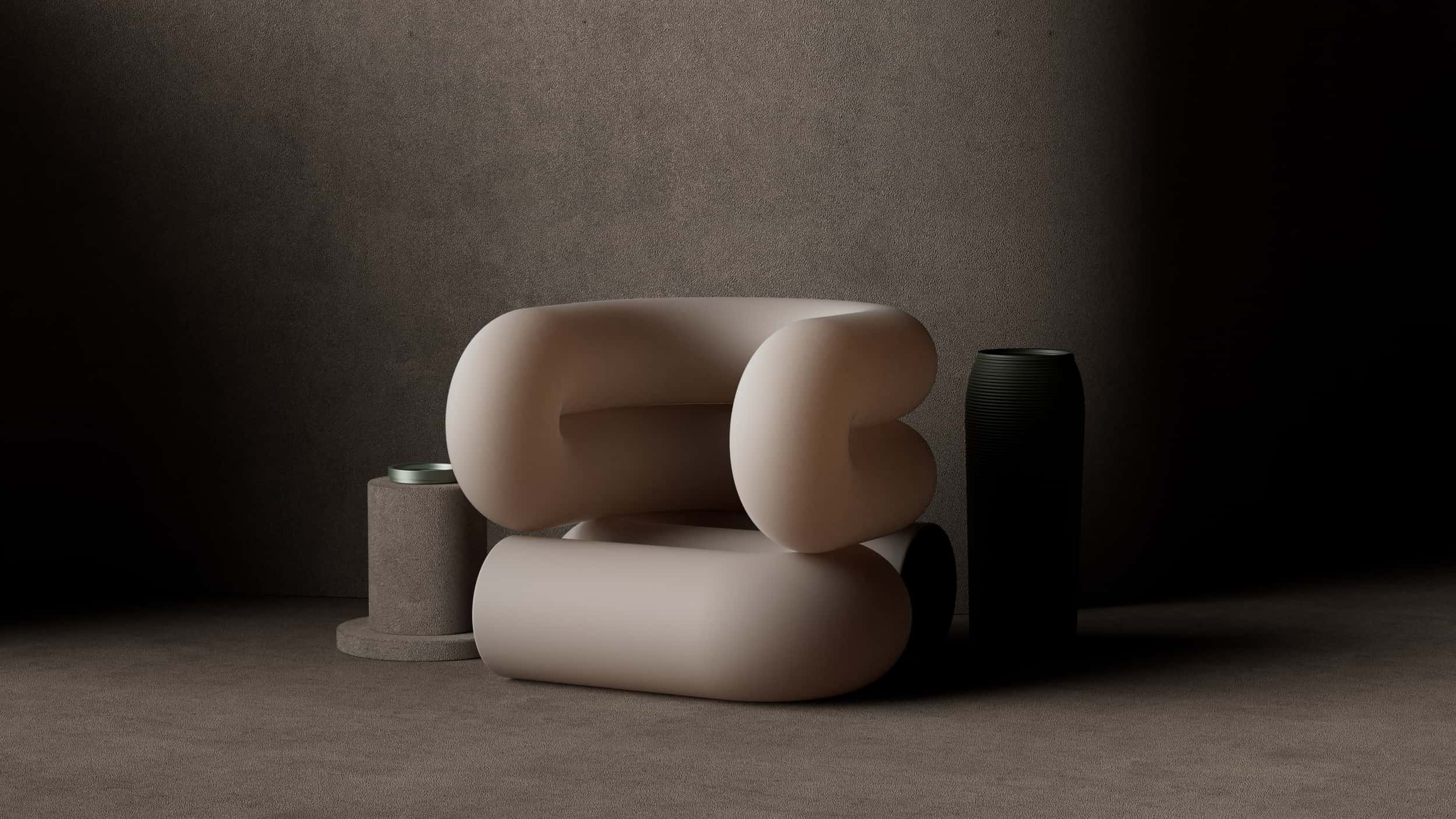 Objets décoratifs modernes dans des tons neutres, comprenant une sculpture abstraite en forme de C, deux cylindres, dont un en béton, et un vase noir vertical sur une surface en tissu gris foncé.